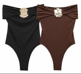 Black and brown swimsuits with decorative bows on a white background