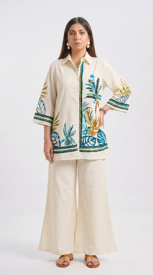 Woman wearing a cream outfit with floral embroidery on a white background