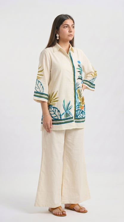 Woman wearing a cream outfit with a floral pattern on a white background