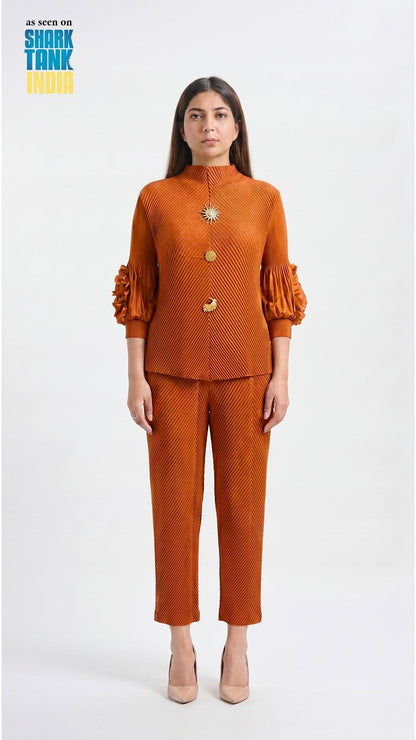 Woman wearing a rust-colored outfit with gold buttons on a white background