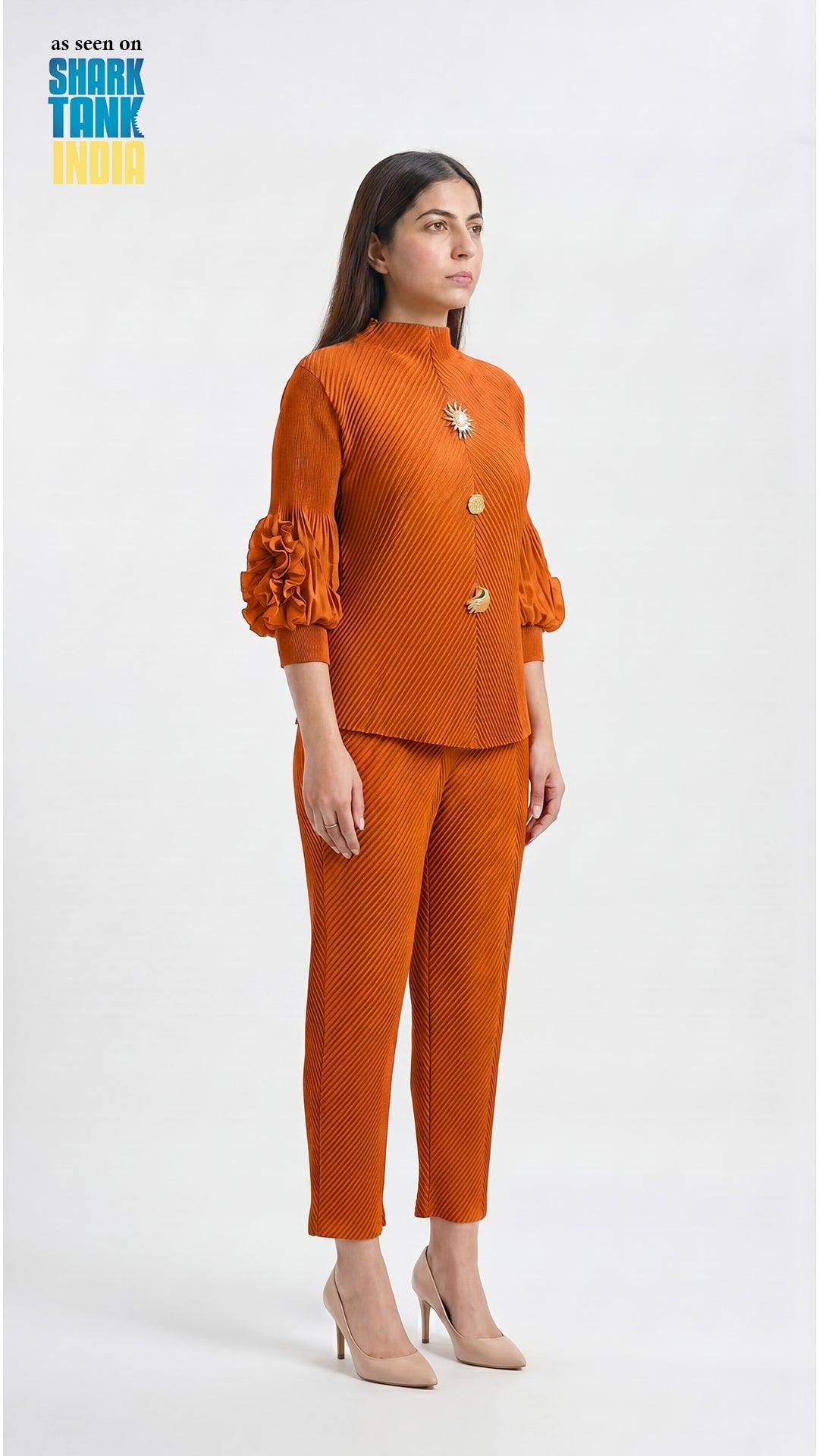 Woman wearing an orange outfit with a matching jacket and pants on a white background.