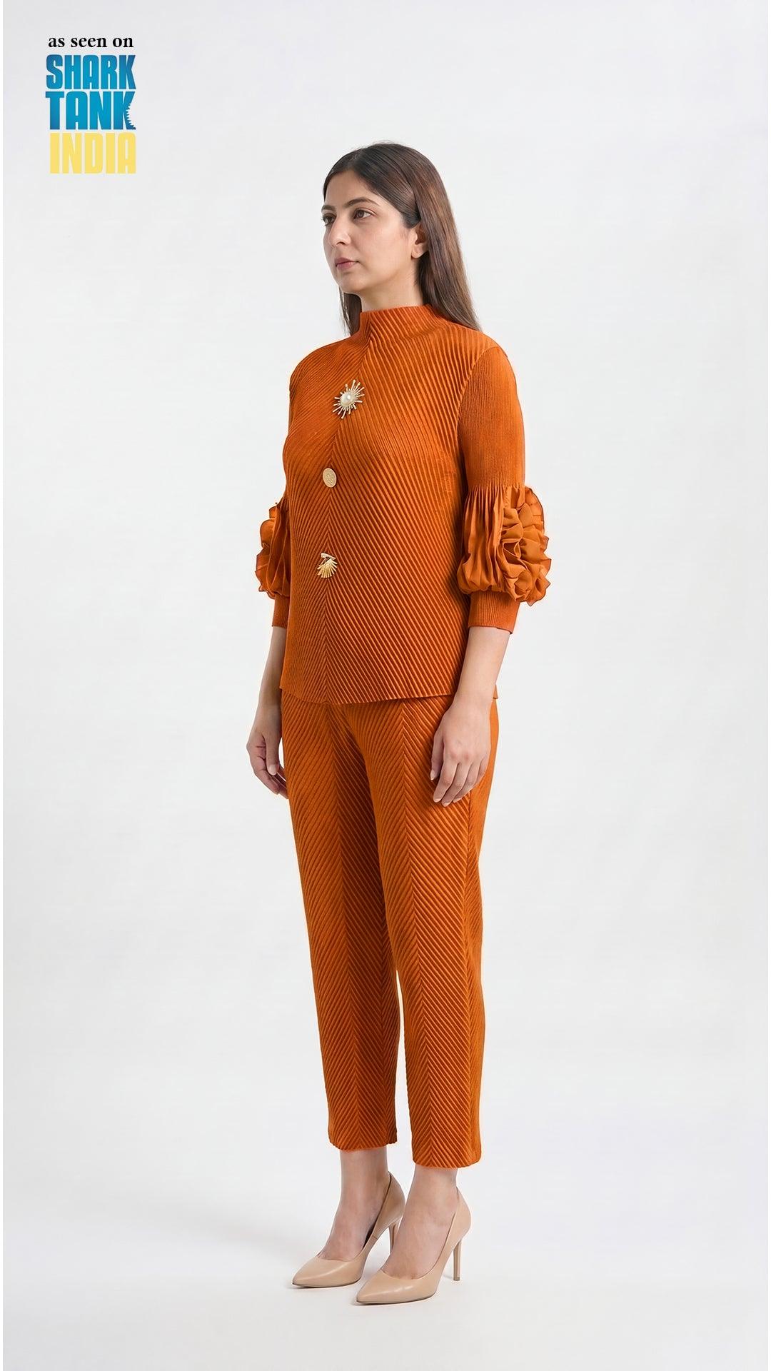 Woman wearing an orange textured outfit with ruffled sleeves on a white background
