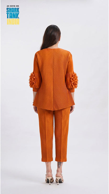 Woman wearing an orange textured suit on a white background