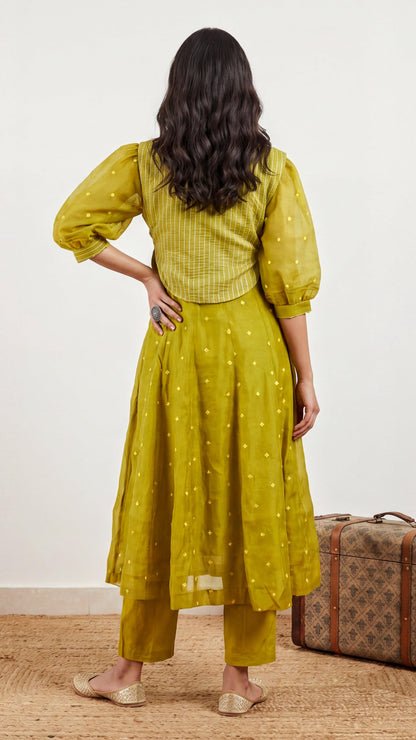 Woman wearing a yellow dress with a vintage suitcase on a wooden floor.