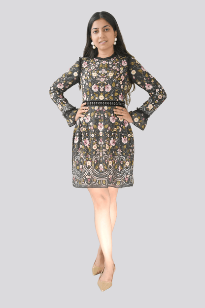 Woman wearing a floral dress standing in front of a plant on a white background