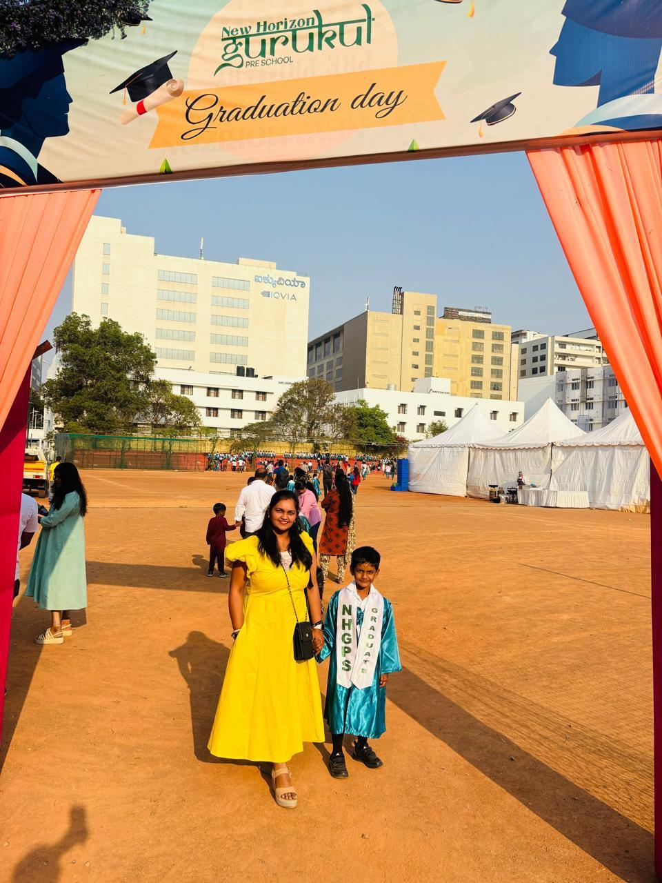 Graduation ceremony with a 'New Horizon Stirlukul' banner and people in graduation attire.