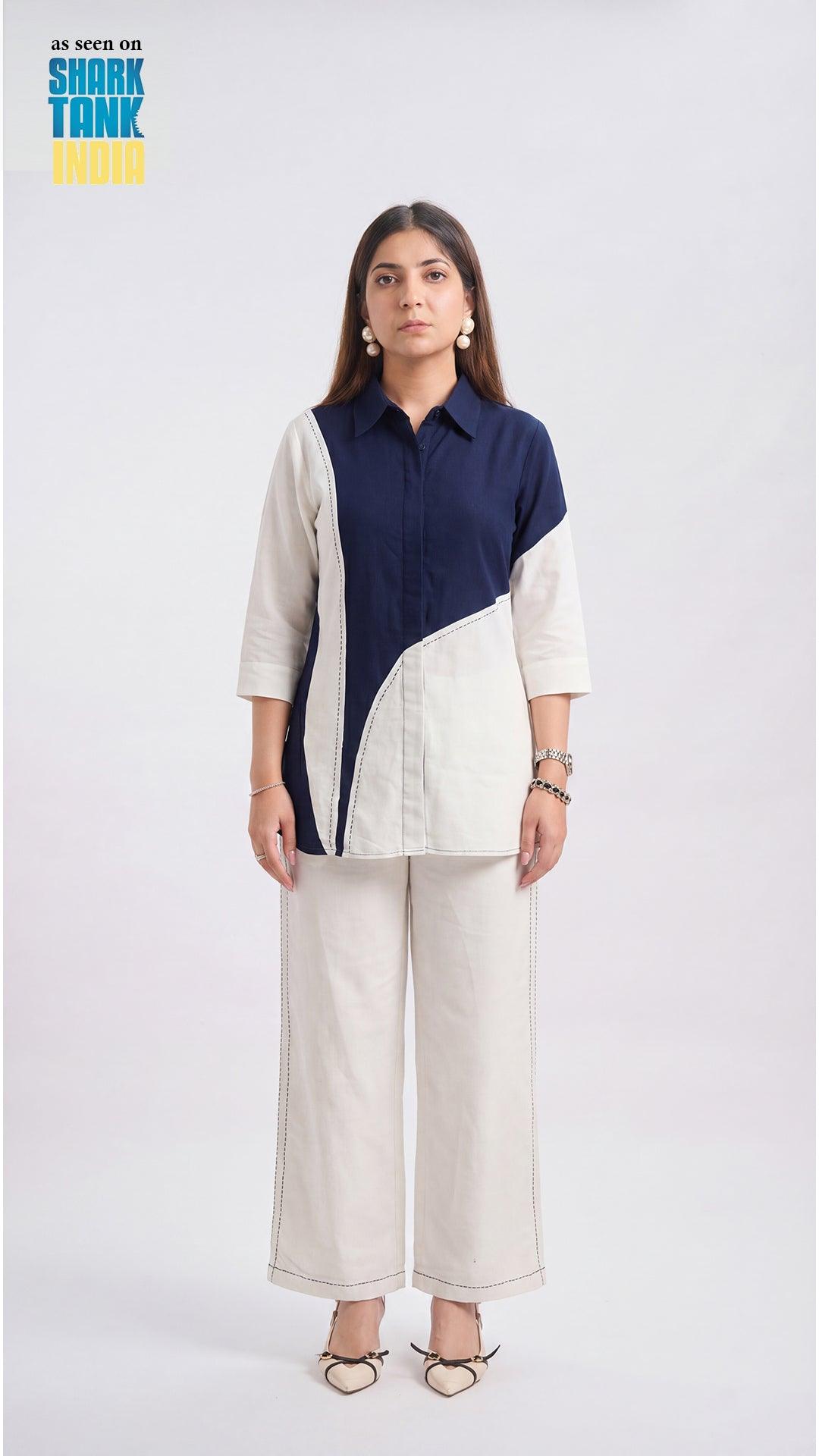Woman wearing a two-tone shirt and white pants on a white background with 'Shark Tank India' logo.