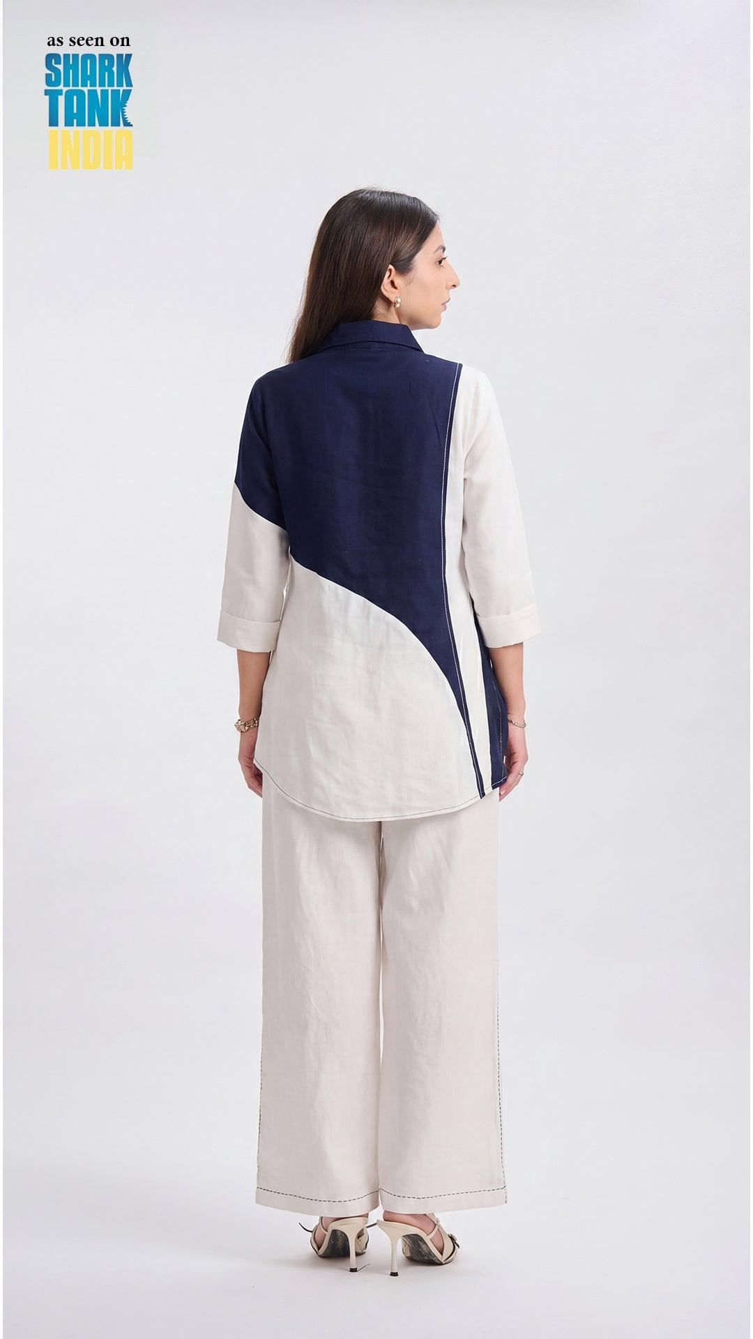 Woman wearing a two-tone jacket with navy and white on a white background