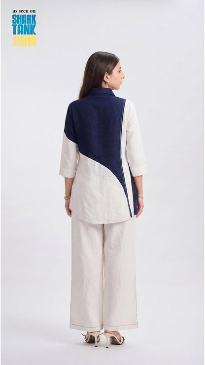 Woman wearing a two-tone jacket with navy and white on a white background