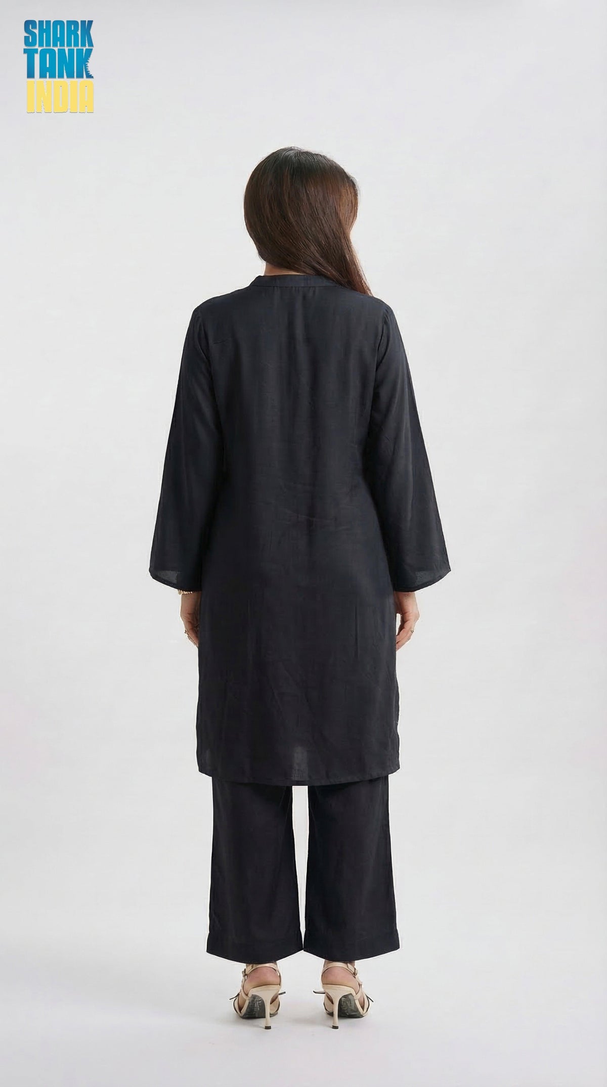Person wearing a black outfit with wide-leg pants on a white background
