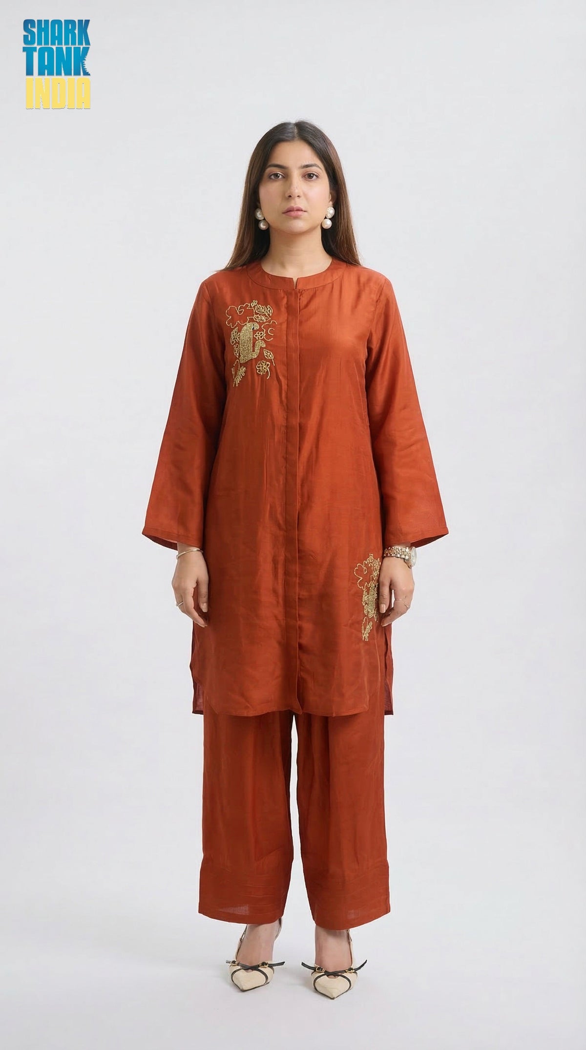 Woman wearing a rust-colored kurta with pants on a white background
