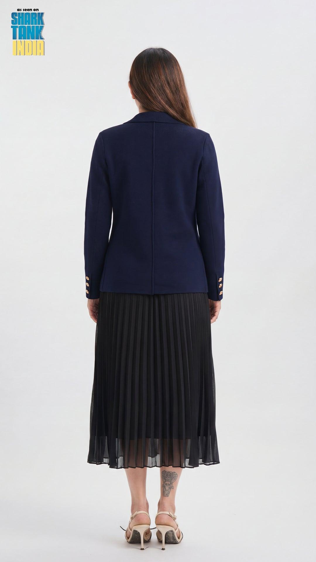Woman wearing a navy blue cardigan and black pleated skirt on a white background