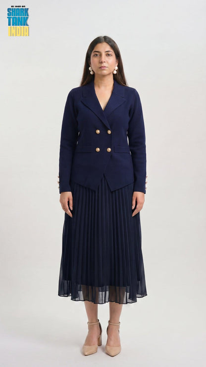Woman wearing a navy blue blazer and pleated skirt on a white background
