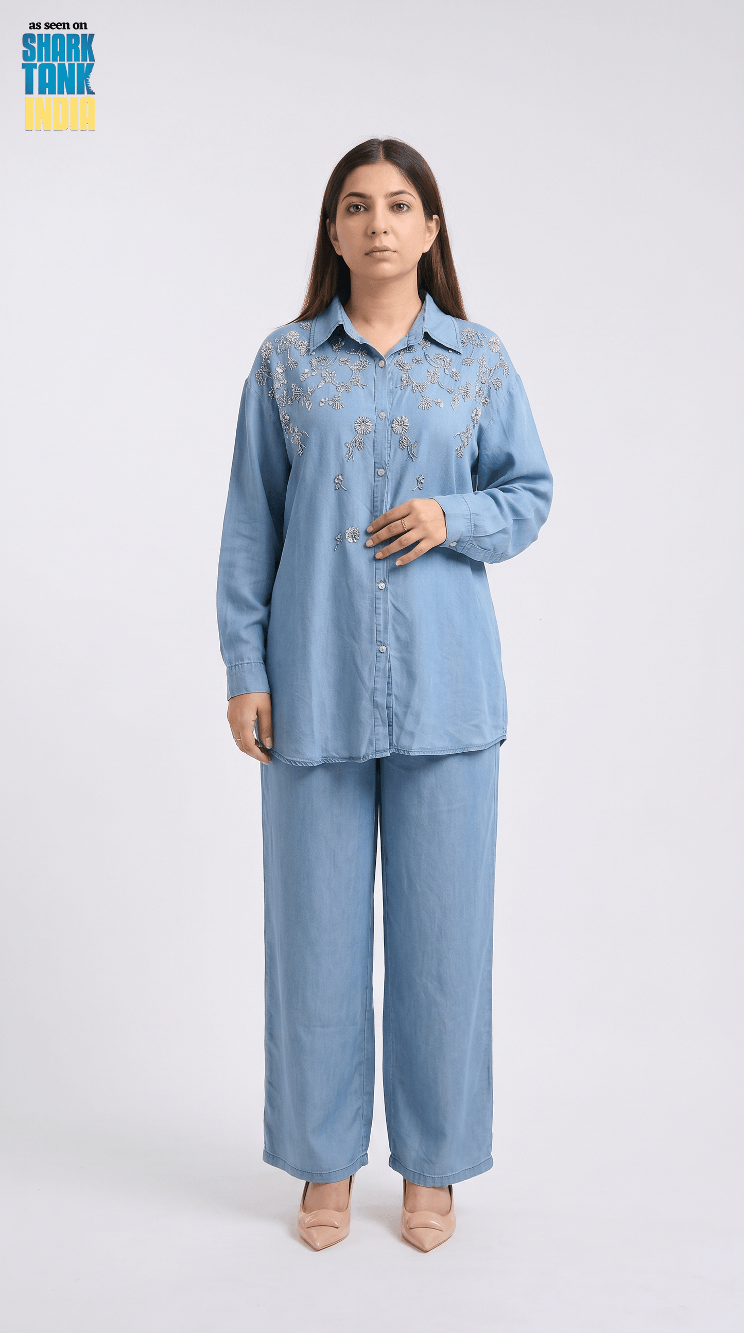 Woman wearing a light blue denim outfit on a white background