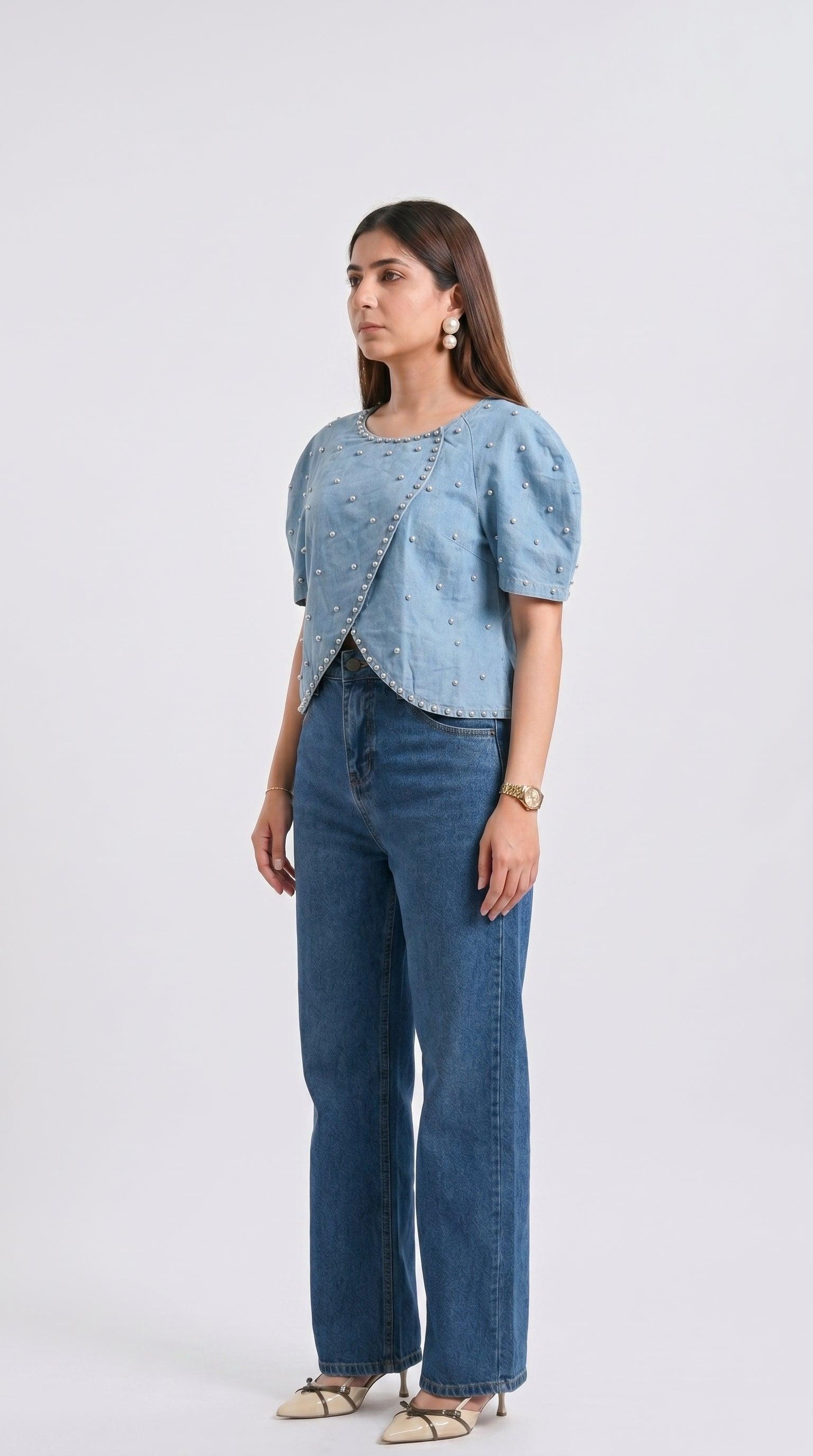 Woman wearing a light blue top and dark blue jeans on a white background