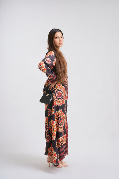 Woman wearing a long, patterned dress on a white background