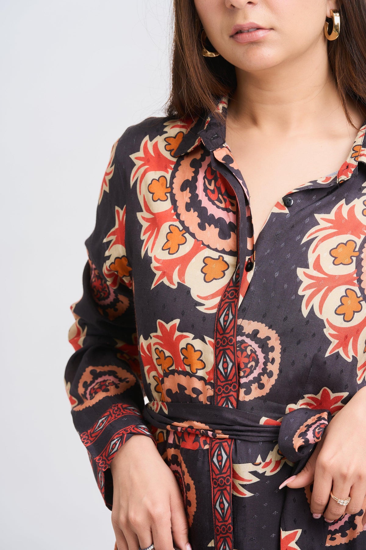 Woman wearing a patterned shirt with a plain background