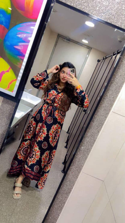 Person wearing a colorful floral dress taking a mirror selfie.