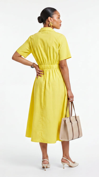 Woman wearing a yellow dress holding a beige handbag on a white background