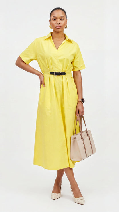 Woman wearing a yellow dress holding a beige handbag on a white background
