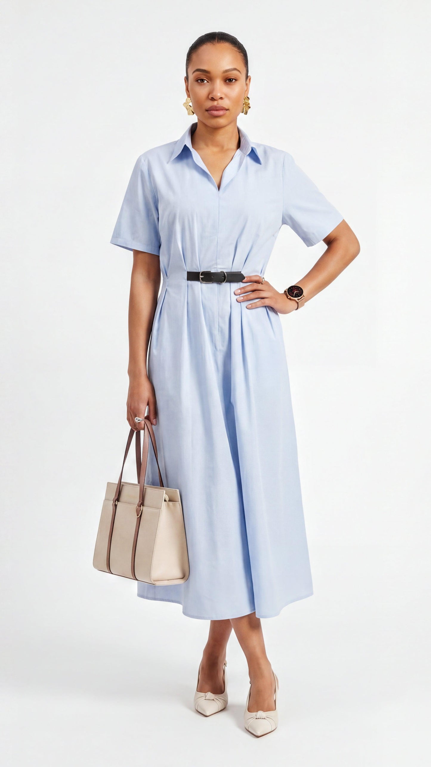 Woman wearing a light blue dress holding a beige handbag on a white background