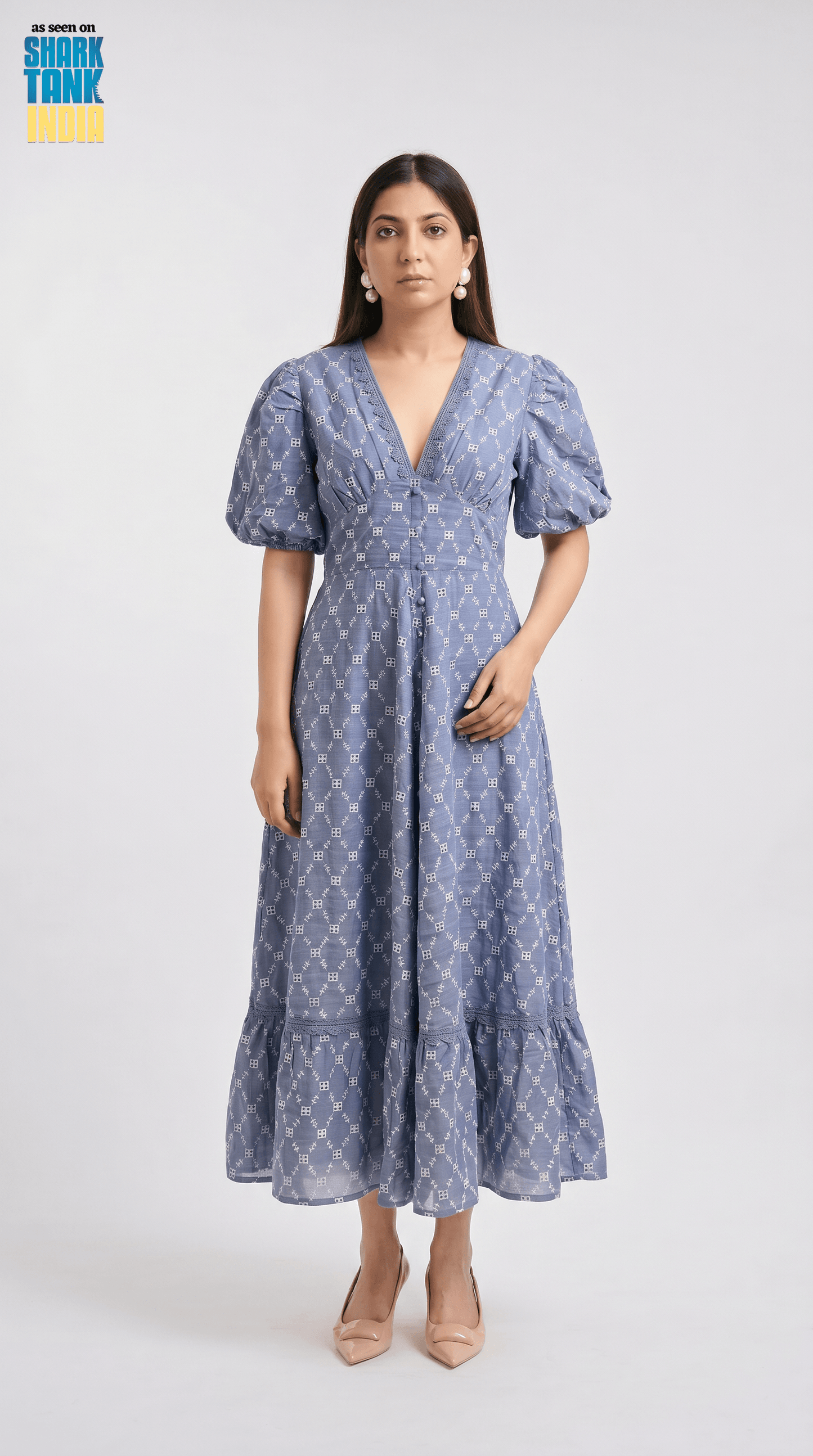 Woman wearing a blue patterned dress on a white background