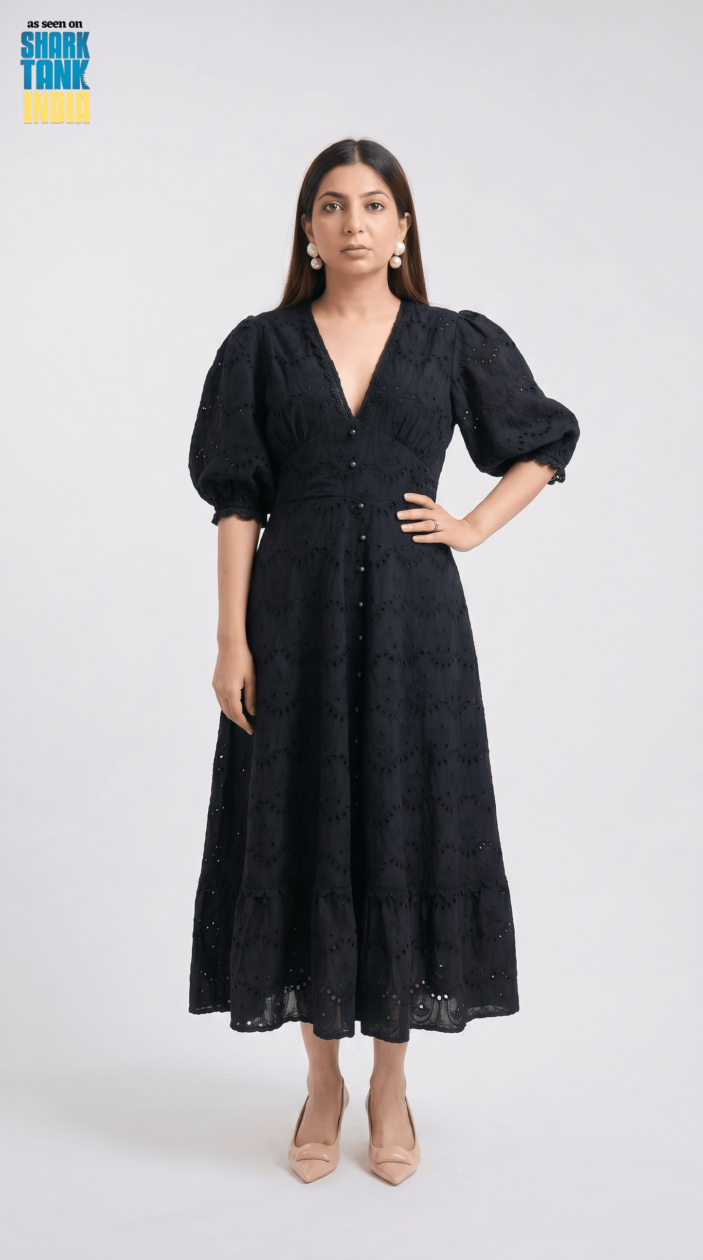 Woman wearing a black dress with puffed sleeves on a white background