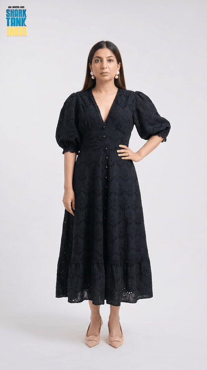 Woman wearing a black dress with puffed sleeves on a white background