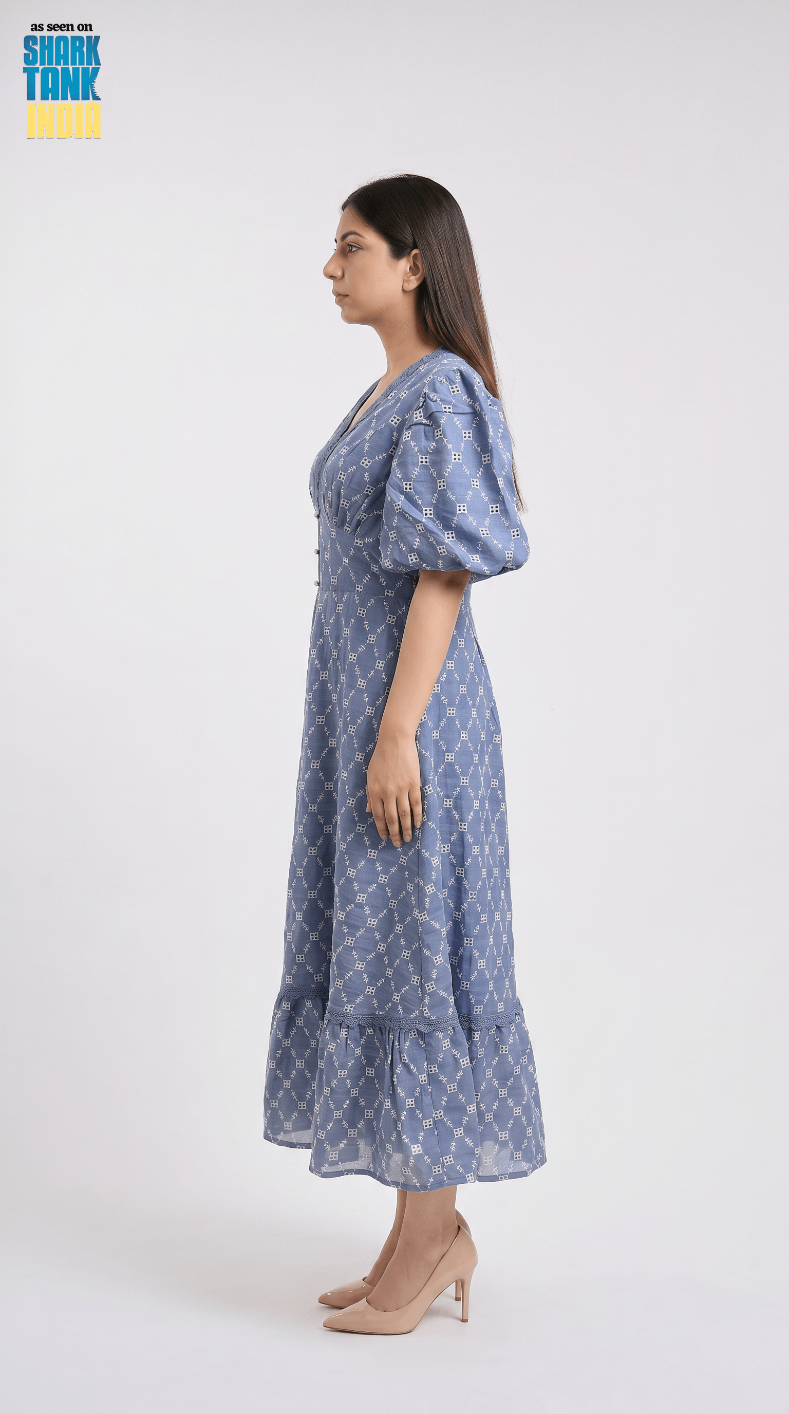 Woman wearing a blue patterned dress on a white background