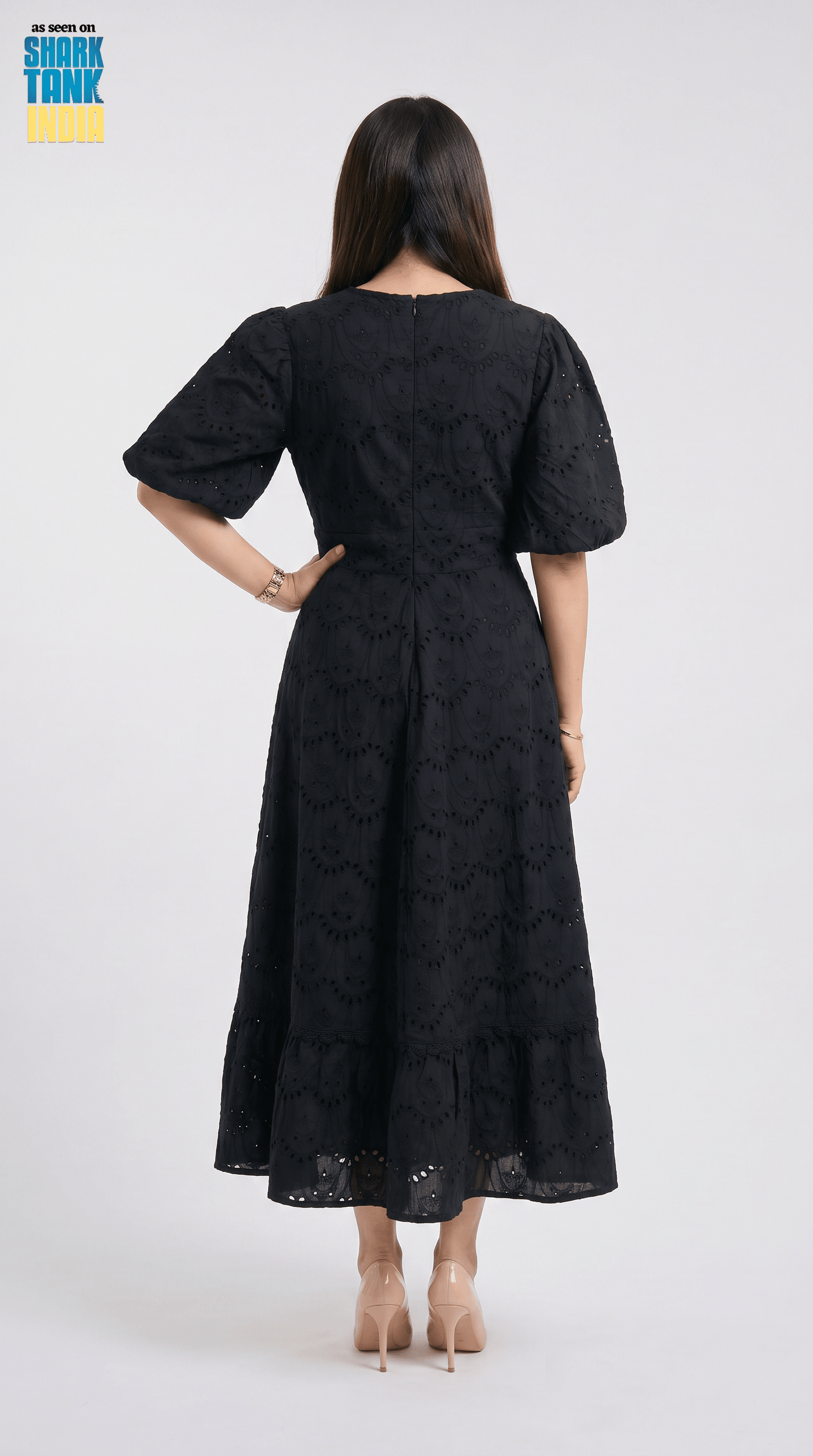 Woman wearing a black dress with a pattern on a white background