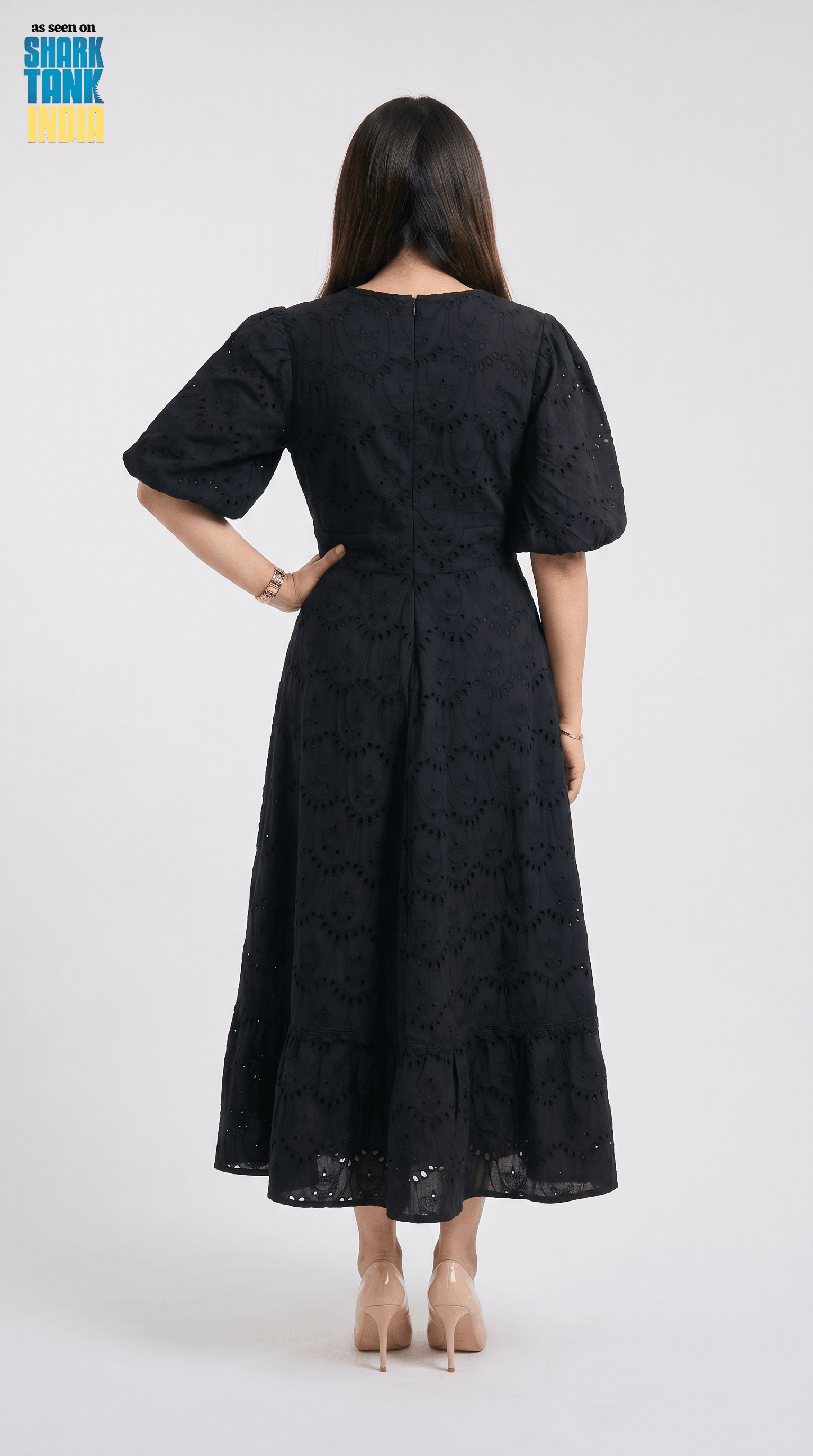 Woman wearing a black dress with a pattern on a white background