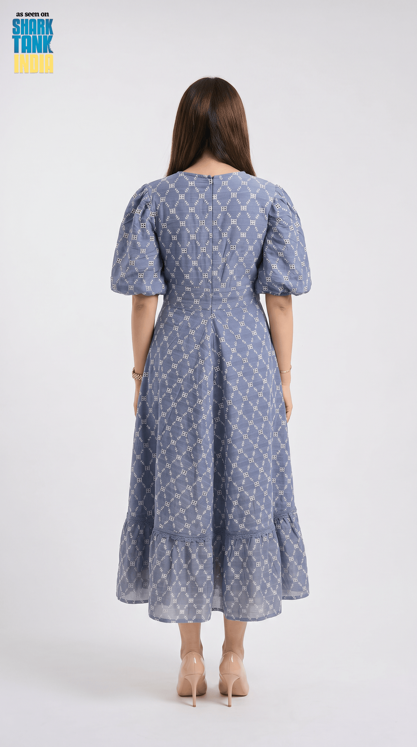 Woman wearing a blue patterned dress on a white background