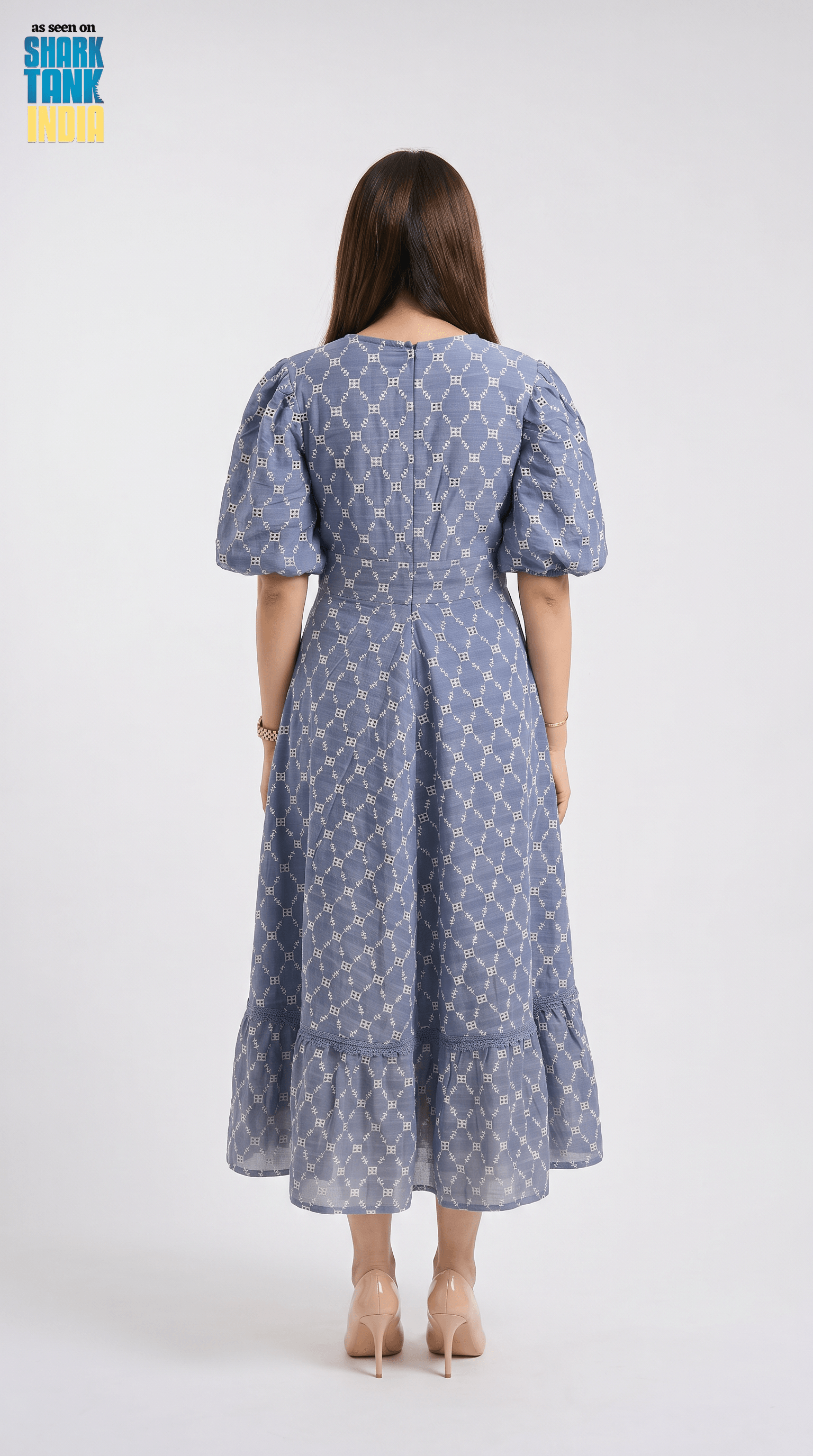 Woman wearing a blue patterned dress on a white background