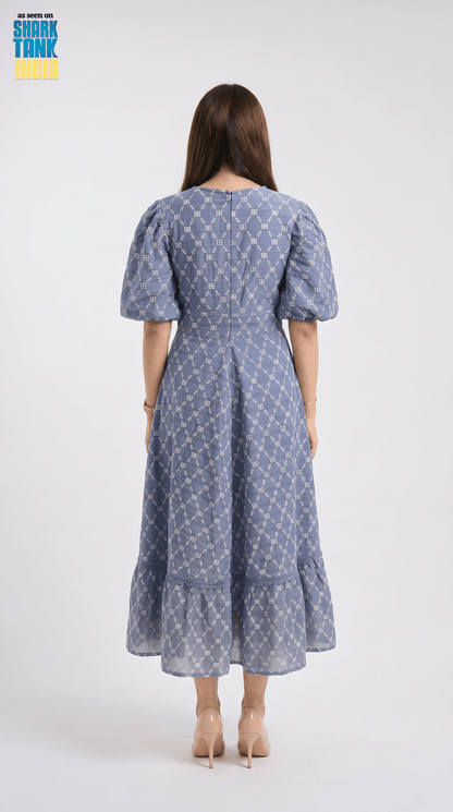 Woman wearing a blue patterned dress on a white background