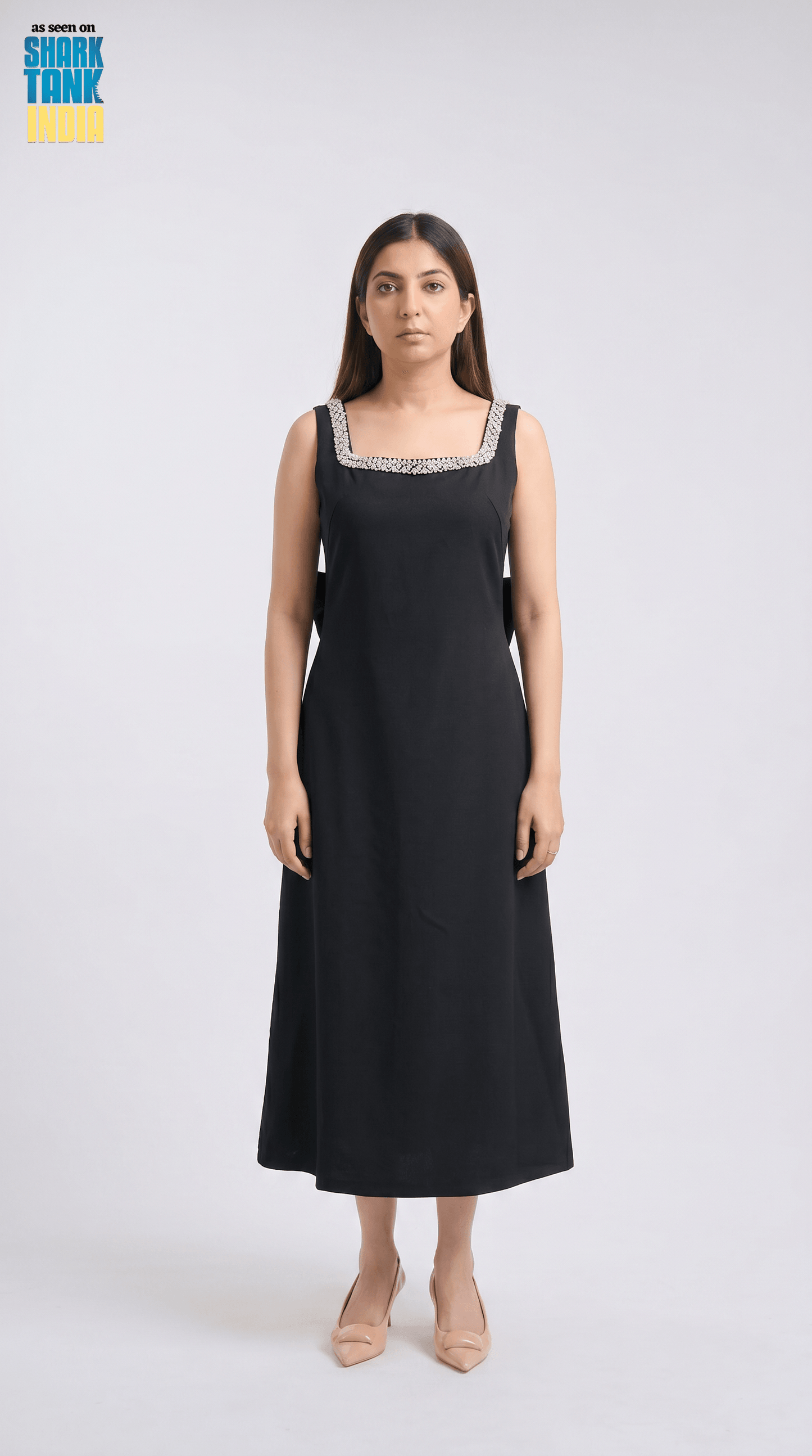 Woman wearing a black dress with lace details on a white background