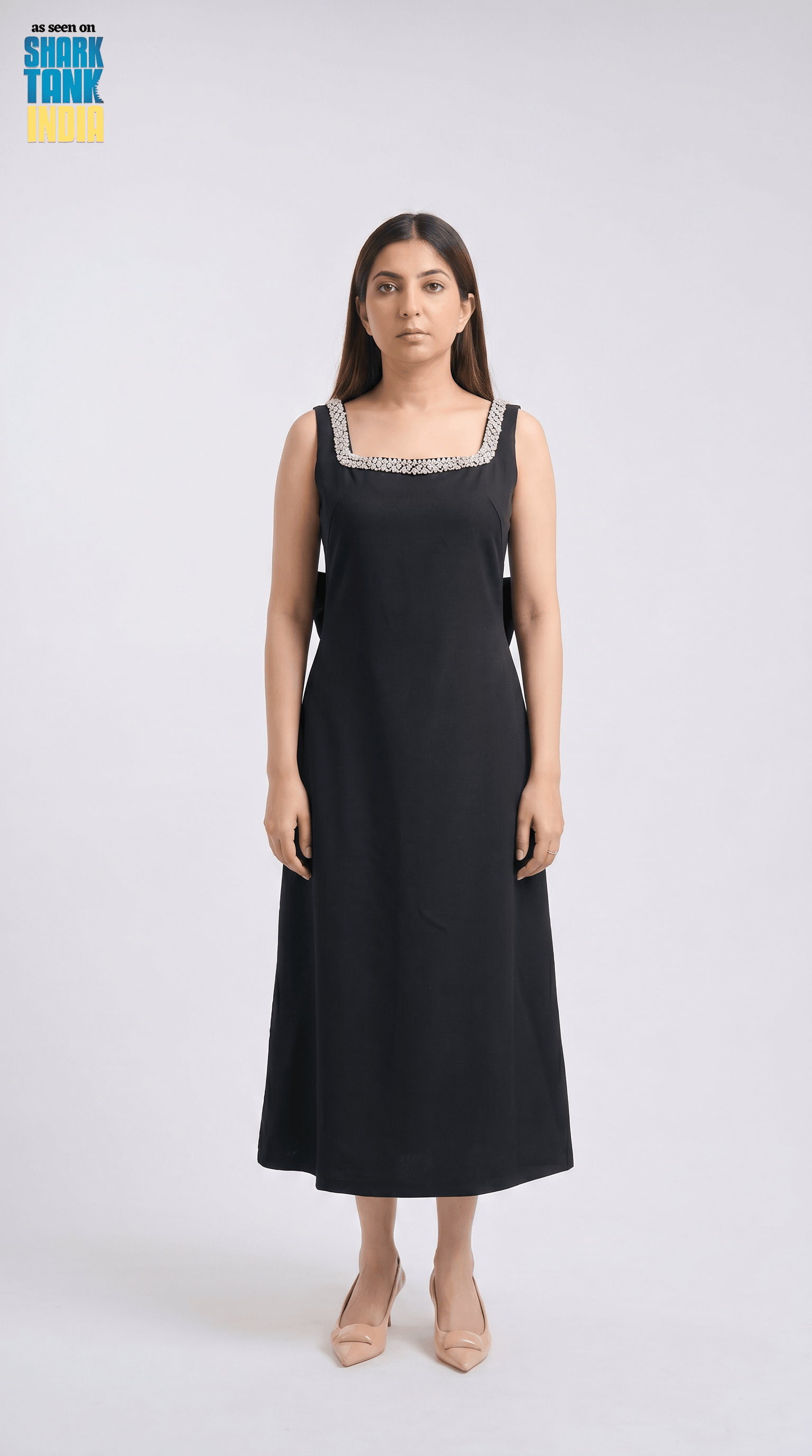 Woman wearing a black dress with lace details on a white background