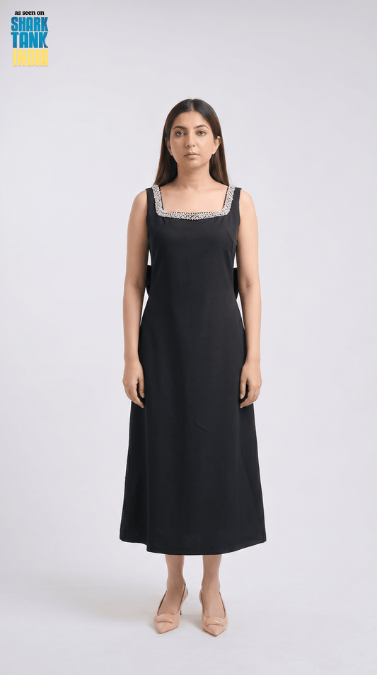 Woman wearing a black dress with lace details on a white background