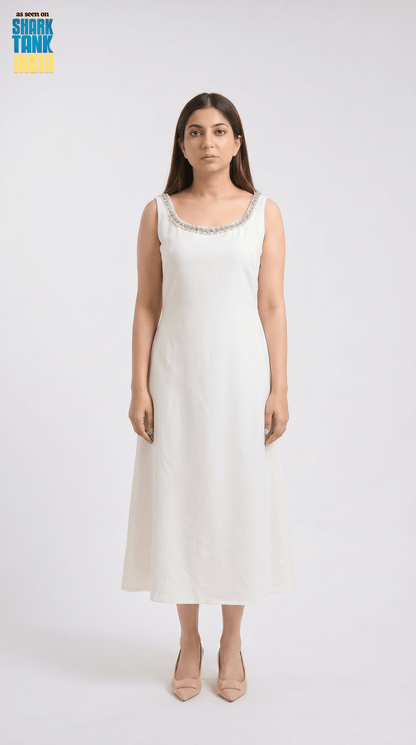 Woman wearing a white sleeveless dress with a subtle pattern on a white background