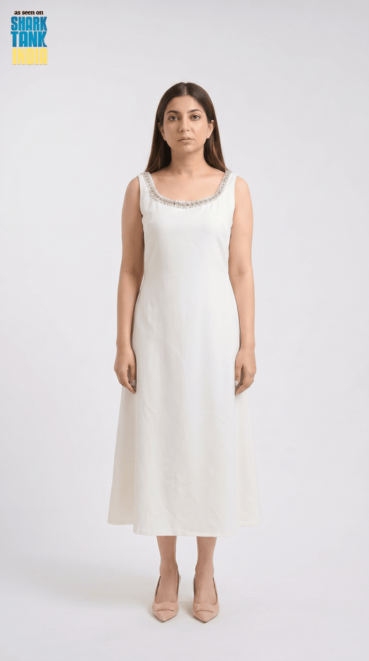 Woman wearing a white sleeveless dress with a subtle pattern on a white background