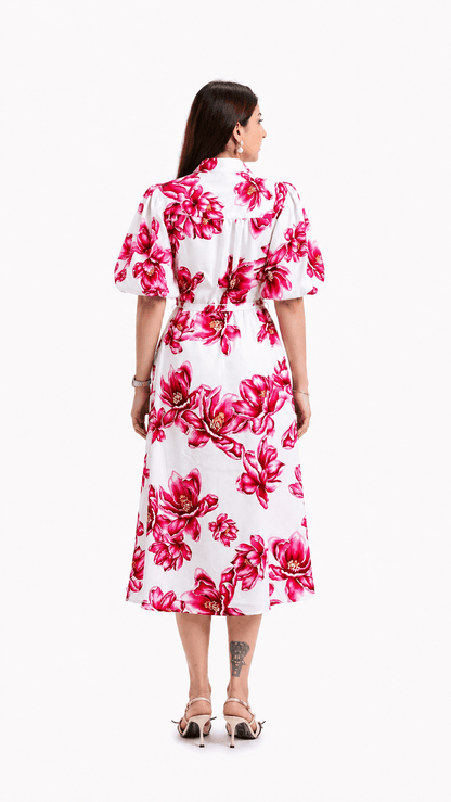 Woman wearing a white dress with pink floral pattern on a white background