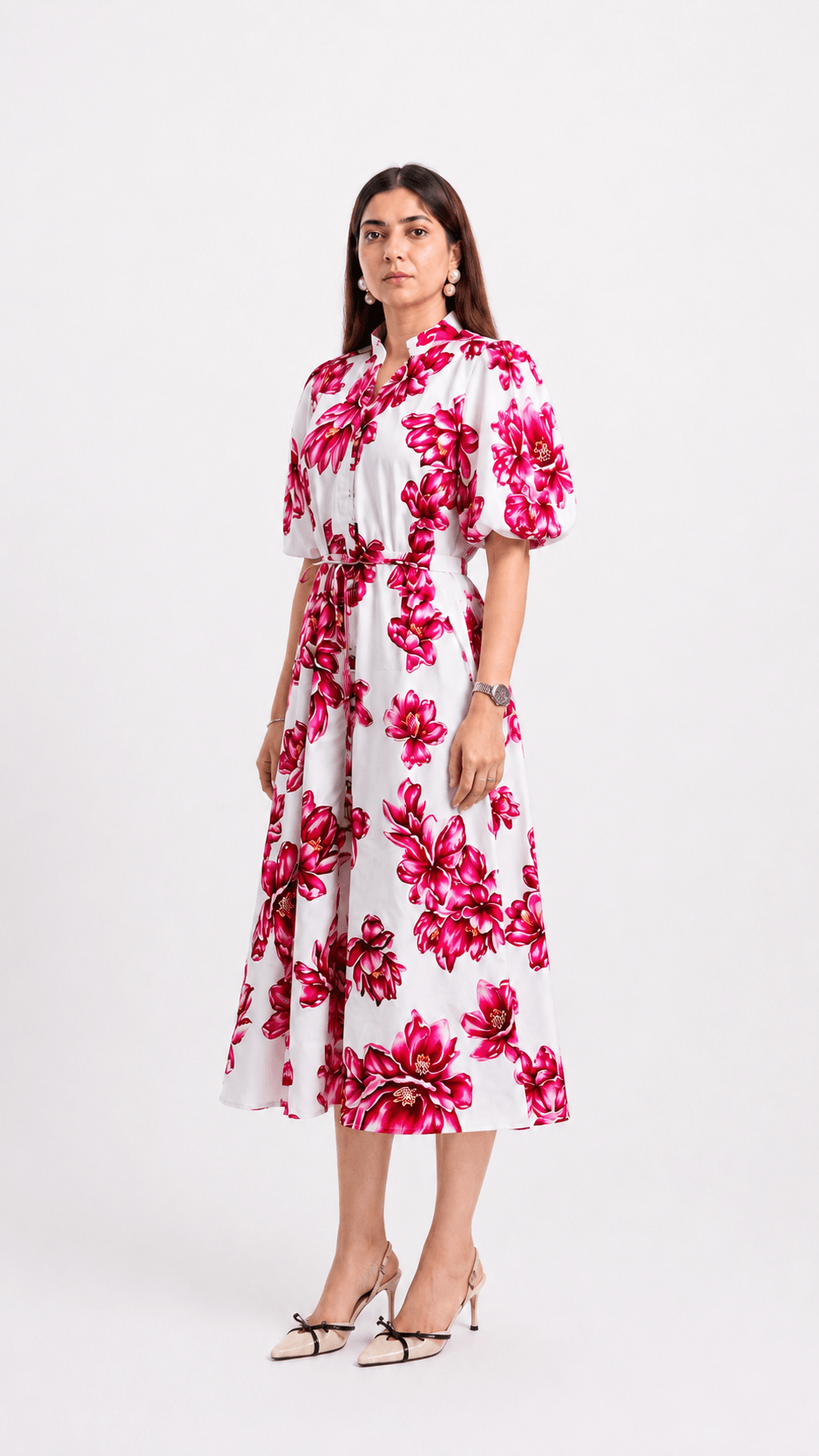 Woman wearing a white dress with pink floral pattern on a white background