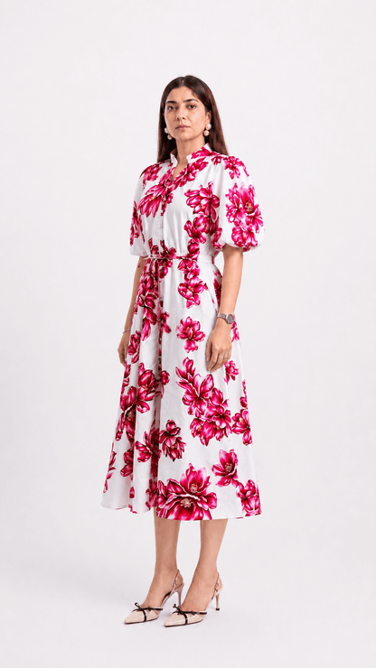 Woman wearing a white dress with pink floral pattern on a white background