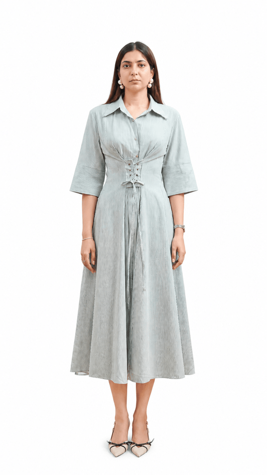 Woman wearing a light gray dress with a belt on a white background
