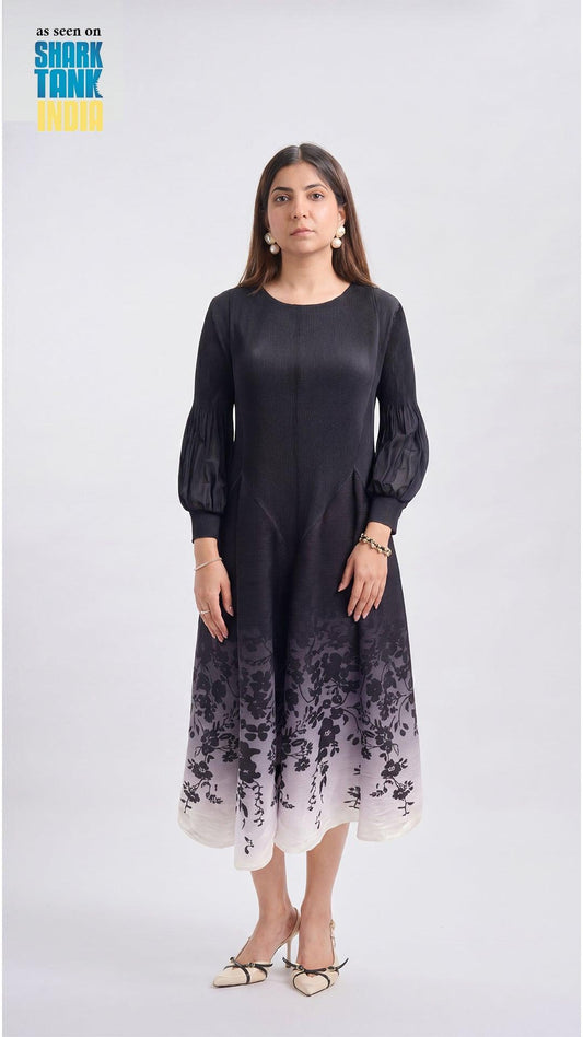 Woman wearing a black dress with floral gradient at the bottom on a white background