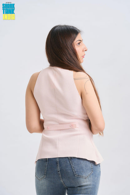 Woman wearing a light pink sleeveless top and blue jeans on a white background