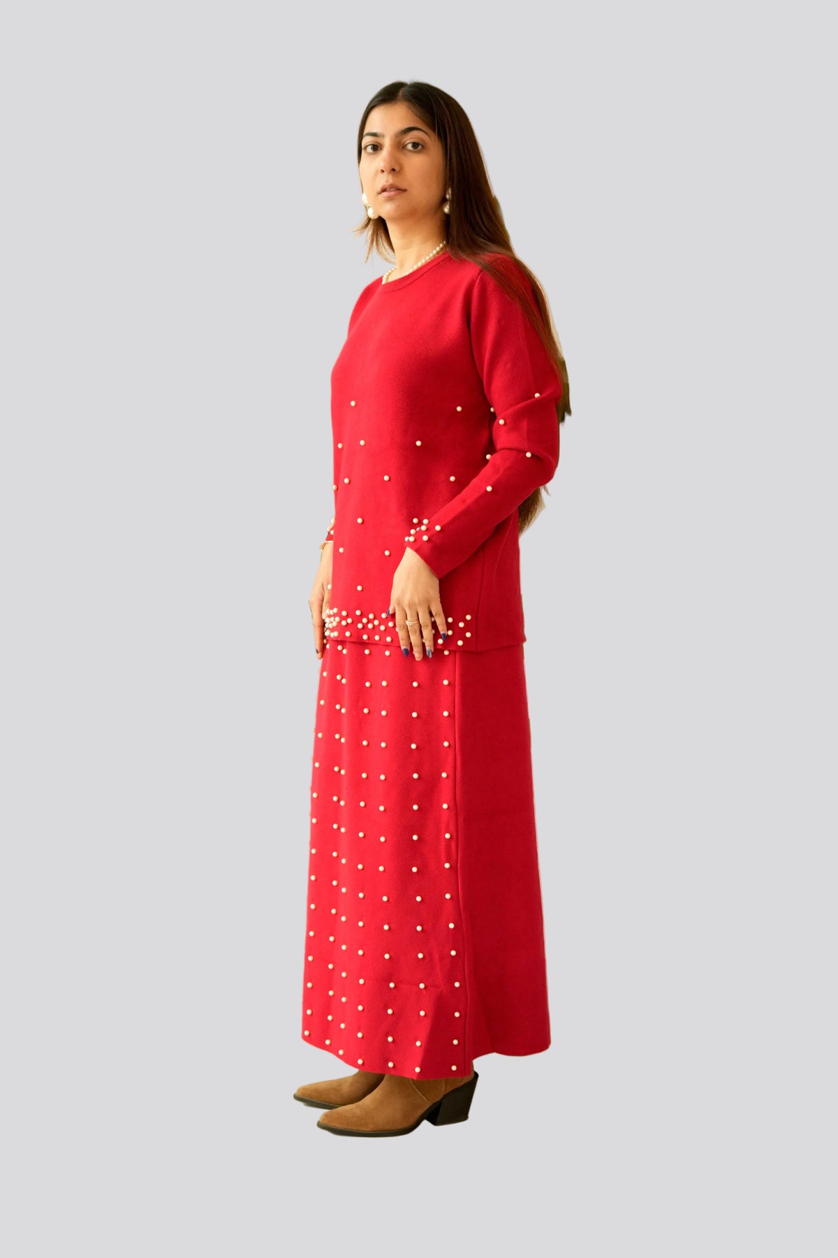 Woman wearing a red dress with white patterns on a gray background