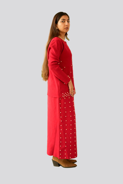 Woman wearing a red outfit with white patterns on a plain background