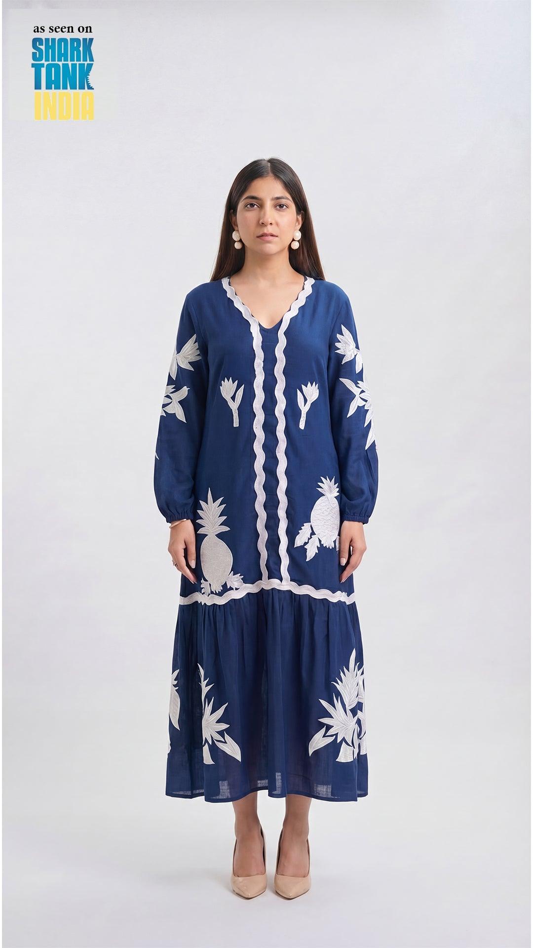 Woman wearing a blue dress with white floral patterns on a white background