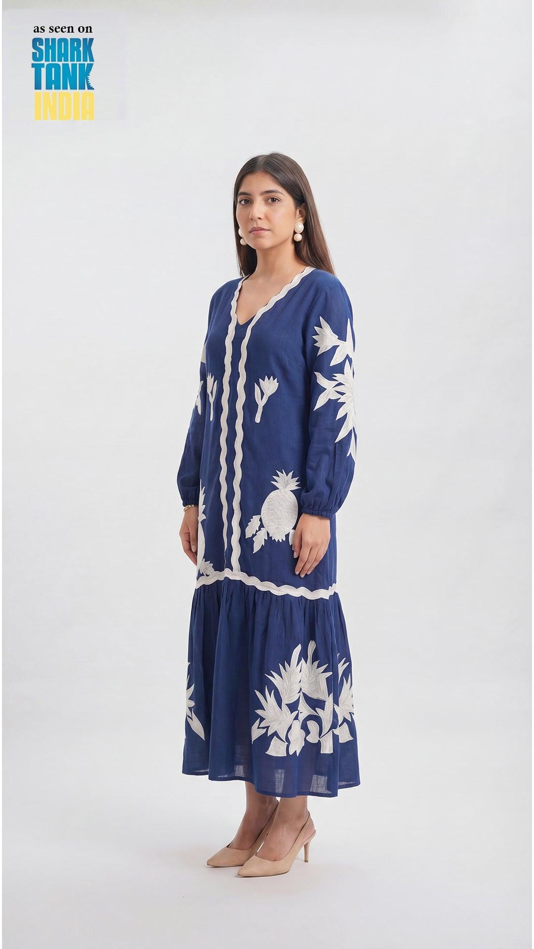 Woman wearing a blue dress with white floral patterns on a white background