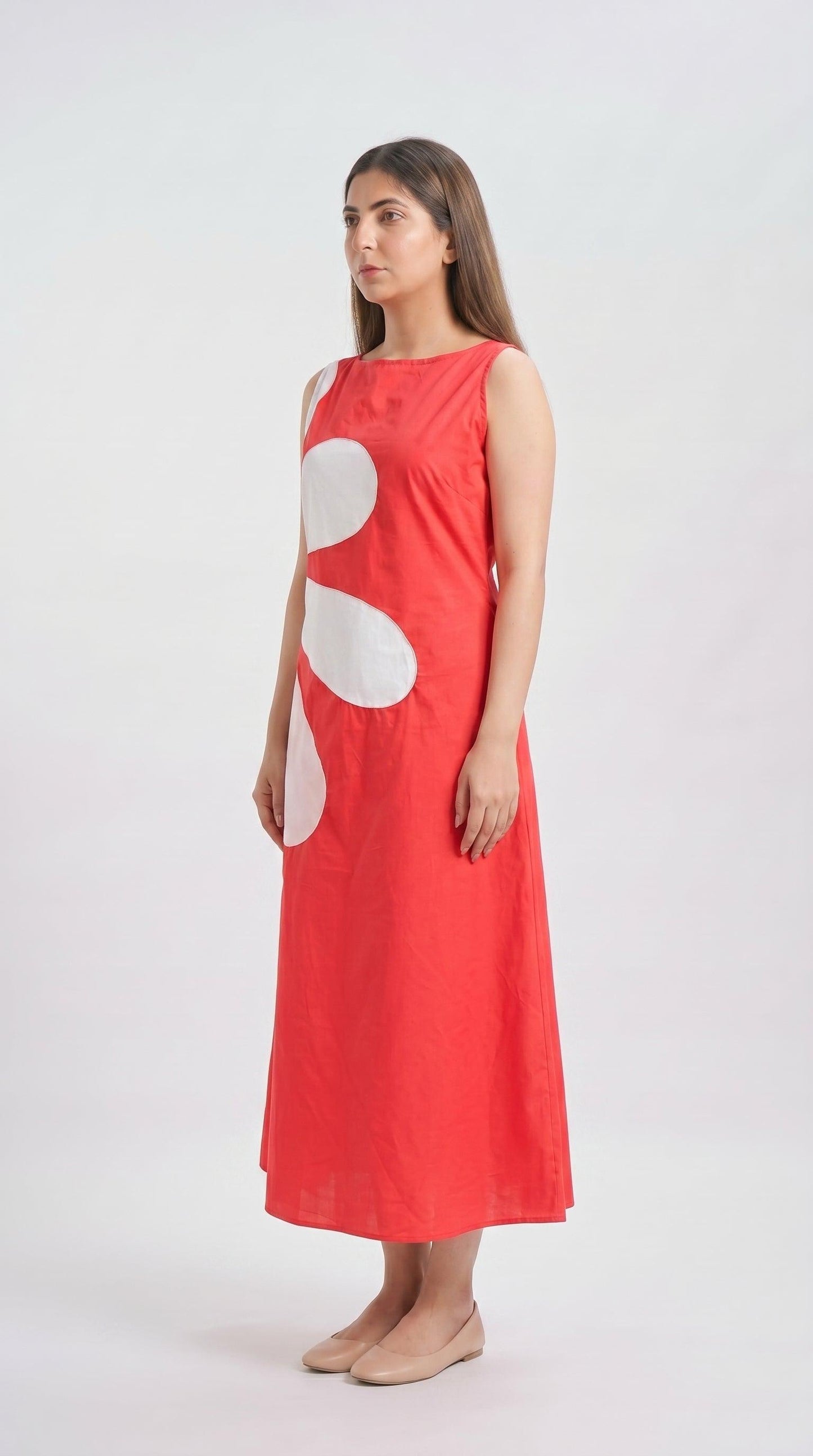 Woman wearing a red dress with a white circle design on a white background